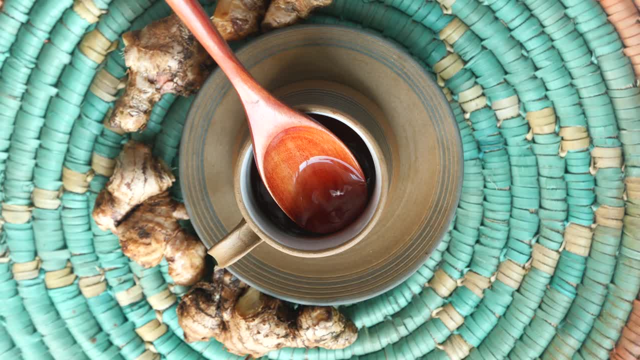 té de jengibre en una taza con cuchara de madera