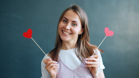smiling woman holding red hearts