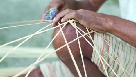 indio de cerca en manos masculinas maestro teje cestas de palos de madera