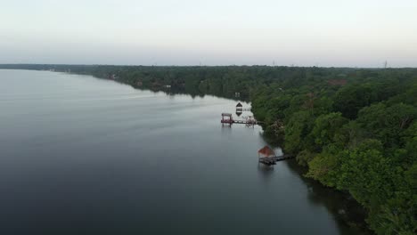 aerial view of a calm lake with lush greenery and gazebos