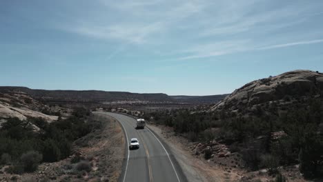 Drone-track-camper-van-truck-on-highway-revealing-Utah-plateau-landscape