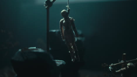 miniature mummified dolls hanging on the gallows at night