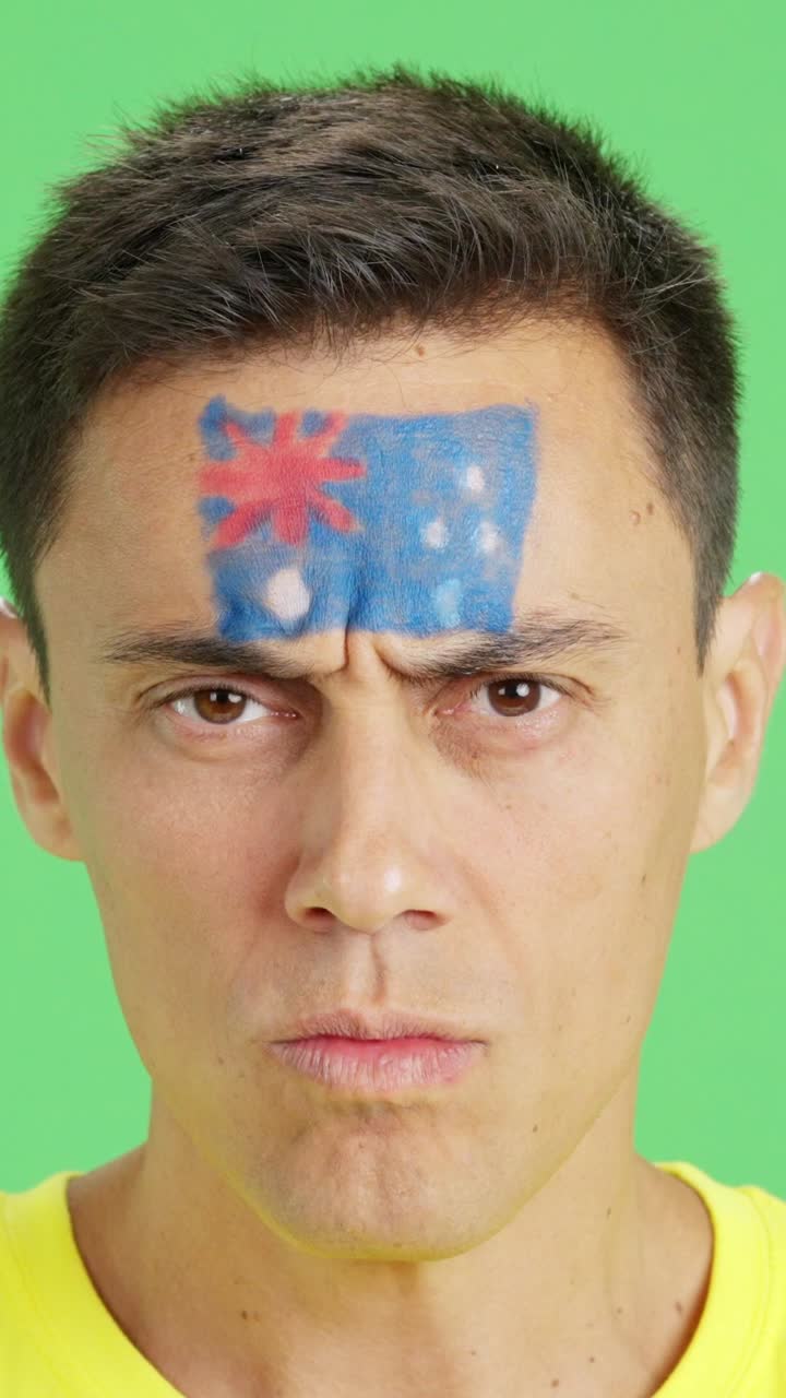 Serious man with a australian flag painted on the face