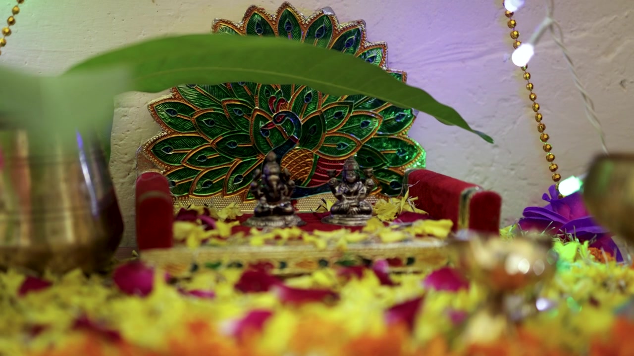 Altare domestico indù tradizionale con idoli di Lakshmi e Ganesha e decorazioni festive.