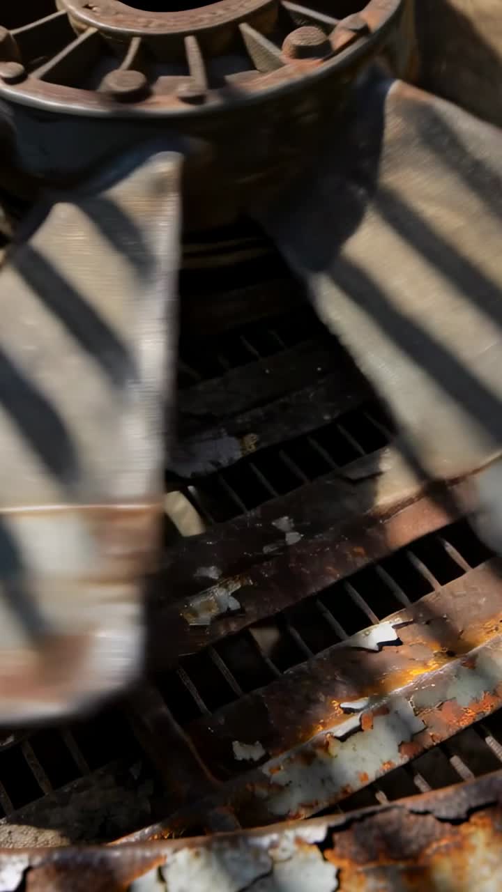 Vertikal video: Kamera panorerer hen over rusten aksialventilatorvinge og nav i kabinet, der viser rust.