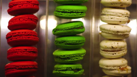 scrolling closeup view of vibrant red, green, and cream french macaron pastries