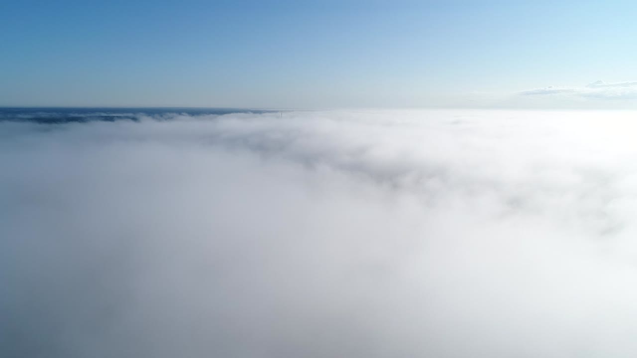 vuelo sobre nubes brumosas a la luz del sol de la mañana con poca gloria y paisaje urbano bajo las nubes