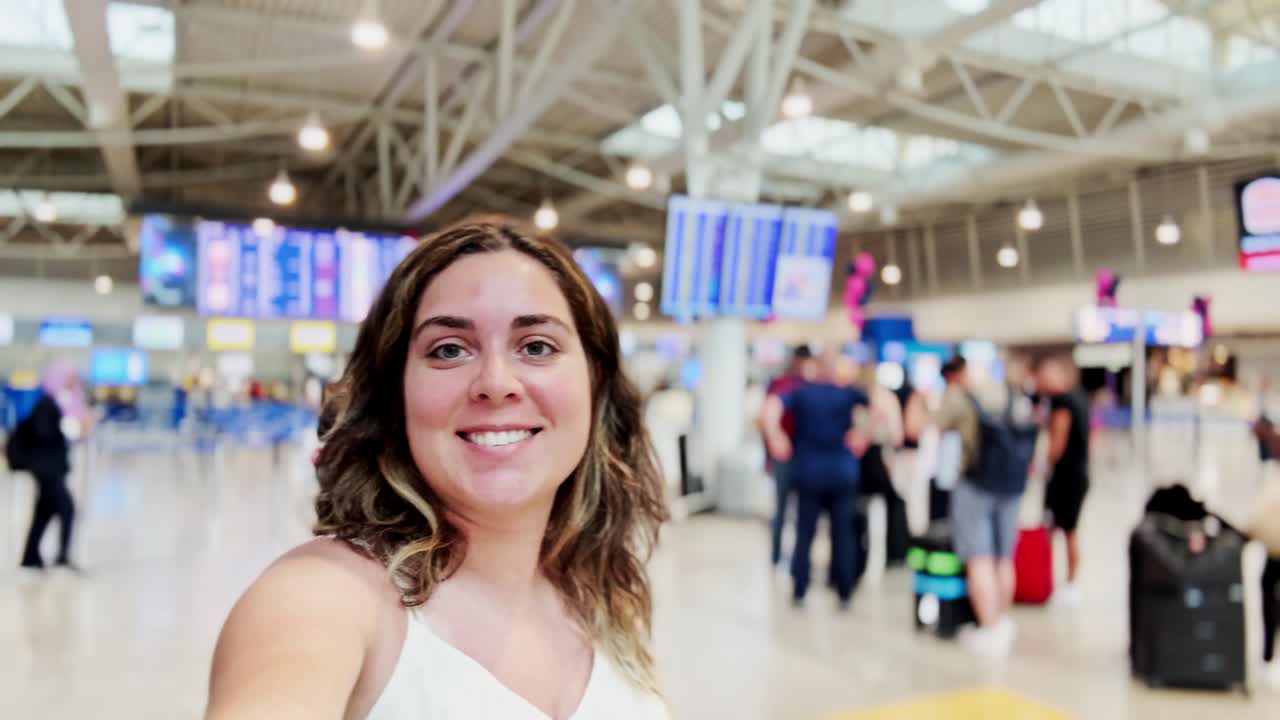 Donna che guarda le informazioni sui voli sul tabellone delle partenze dell'aeroporto