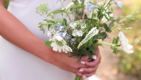 close up of bridesmaid holding small wildflower wedding bouquet in her hands outdoors 1080p 60fps