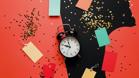 alarm clock amid colorful tags and festive confetti