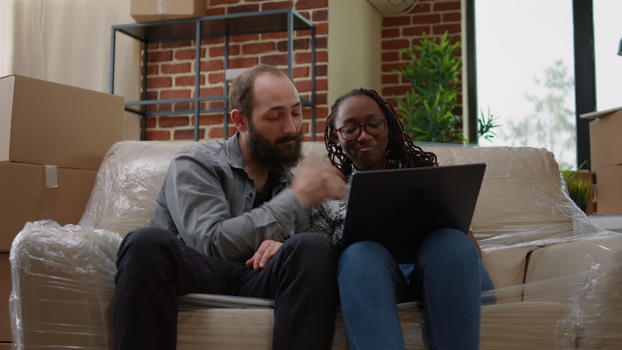 Multiethnic couple finding home decor inspiration on laptop