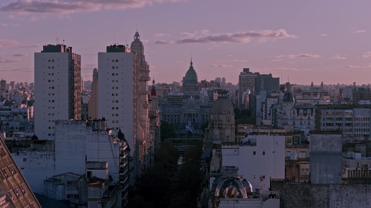 Vista aerea da drone dello skyline urbano di Buenos Aires durante un sereno tramonto, con la cupola storica del Congresso Nazionale e l'architettura classica che si fonde con gli edifici moderni della città
