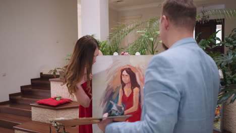 a couple admiring a portrait painting in a stylish home studio