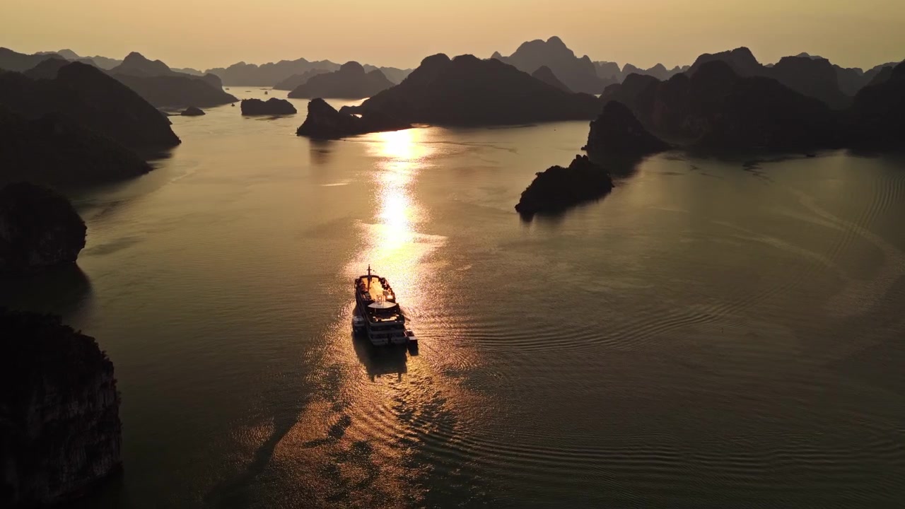 Mặt trời vàng phản chiếu trên mặt nước yên bình của Vịnh Hạ Long với tàu du lịch ở Việt Nam. - Ảnh chụp từ trên không