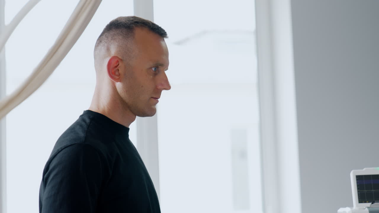 Mid aged Caucasian male standing in the hospital room. Side view portrait. Puzzled and concerned man before wife's labor.