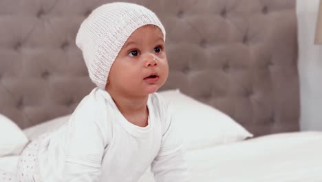 baby in white clothes crawling