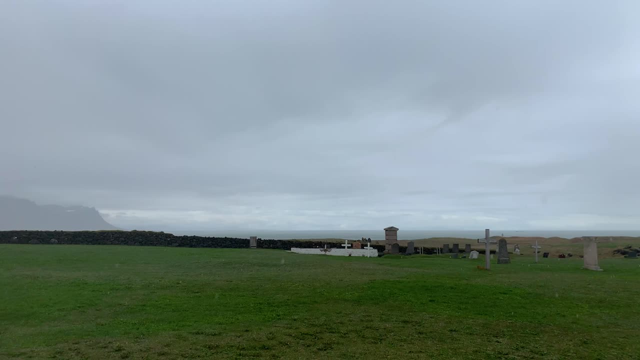 The black church Budakirkja in the south western part of Iceland on the Snæfellsnes peninsula, standing on green grass on a rainy and foggy day