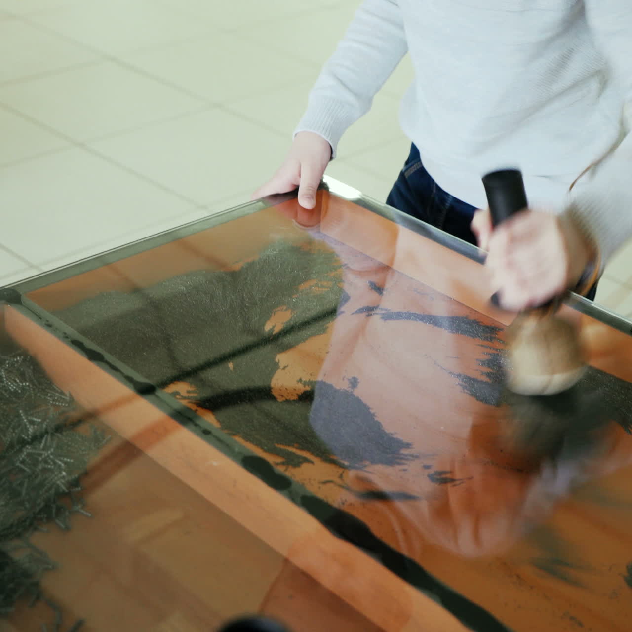 Iron filings in a magnetic field. Boy conducts research experience. Square video