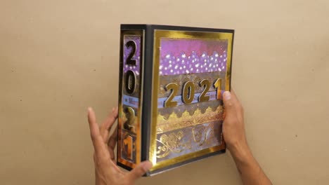 volviendo el archivo de palanca de la palanca del álbum de recortes 2021 con la cubierta de papel dorado en las manos