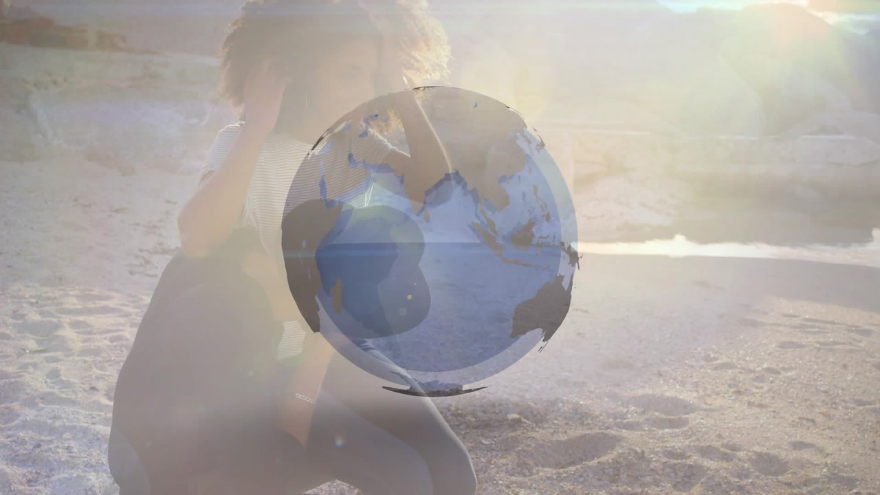 Pair sitting on beach, globe growing, rotating, overlaying them, man adjusting hair for travel