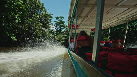 navigating through the canals of tortuguero national park in costa rica. panoramic view of the green lush vegetation and the rainforest. natural reserve for wildlife and biodiversity.