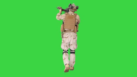 hombre armado en camuflaje con rifle de asalto en busca de un objetivo en una pantalla verde, llave de croma