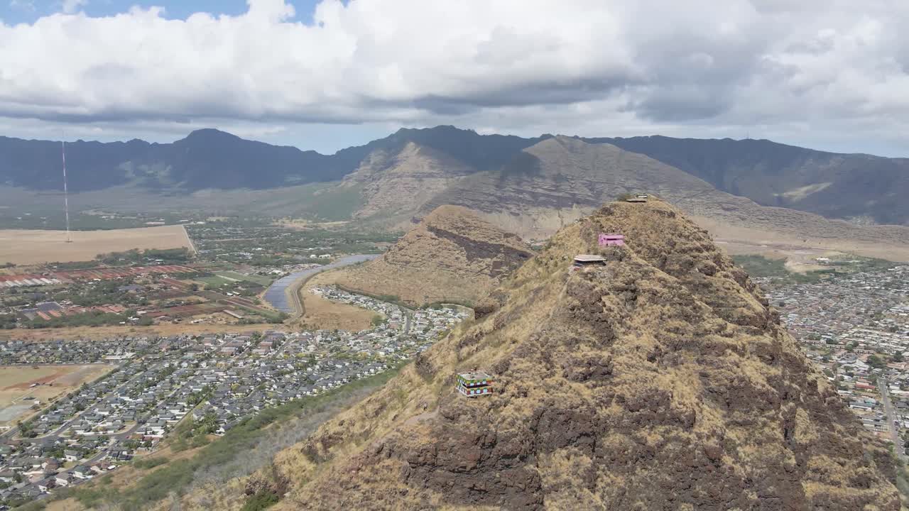 acantilado de montaña con vistas a la cordillera en una isla tropical cerca de la playa y viviendas suburbanas