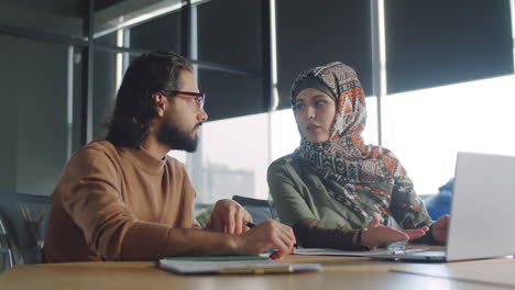 arab businessman talking with female colleague in hijab