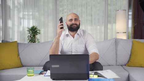 un trabajador de oficina en casa recibe malas noticias por teléfono.