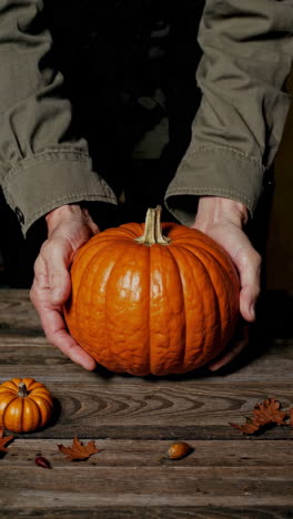 person holding a pumpkin on a rustic wooden table