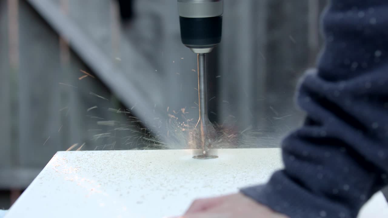 A woman drills into a white board