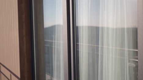 modern building exterior with sheer curtains and a balcony view