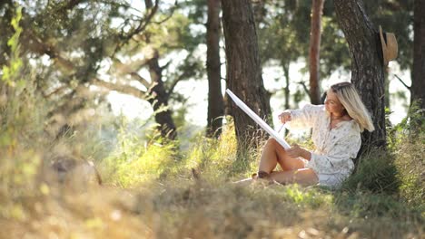 young woman paints a picture under a large tree in a quiet forest embracing the beauty and young woman paints a picture under a large tree in a quiet forest embracing the beauty and tranquility of nature