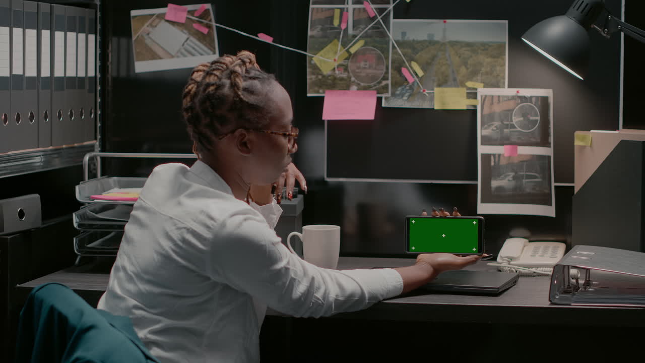 Person in office using a smartphone with green screen