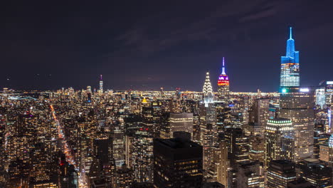 Fly-above-city-downtown-at-night.-Hyperlapse-of-illuminated-high-rise-buildings.-Manhattan,-New-York-City,-USA