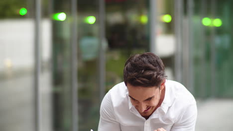 Portrait-man-celebrating-success-outdoors.-Man-talking-phone-outdoors-at-street