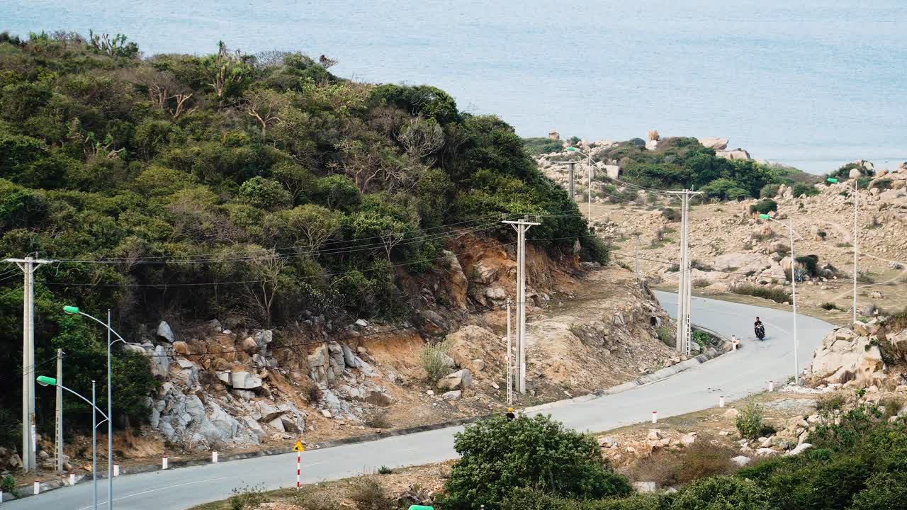 베트남에서 모터사이클을 타고 경치 좋은 도로를 따라 바다를 따라 해안의 야생을 여행합니다.