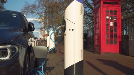 an parked electric vehicle charging at a charging point outdoor in the city.