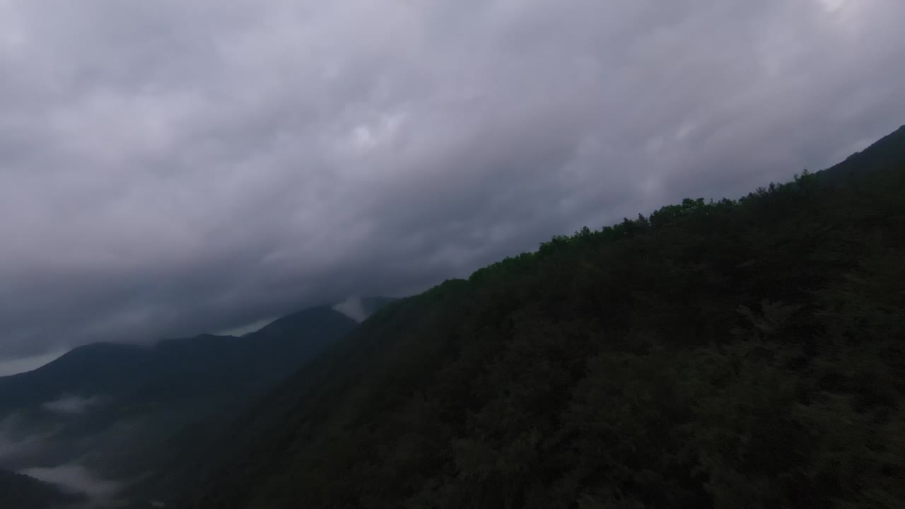 vista aérea volando sobre la exuberante montaña verde de la selva tropical con nubes de lluvia durante la temporada de lluvias en el parque nacional reservado de la montaña doi phuka en el norte de tailandia
