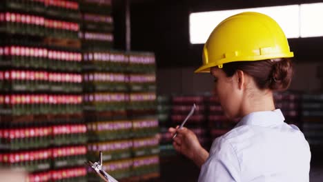 Female-supervisor-maintaining-record-on-clipboard