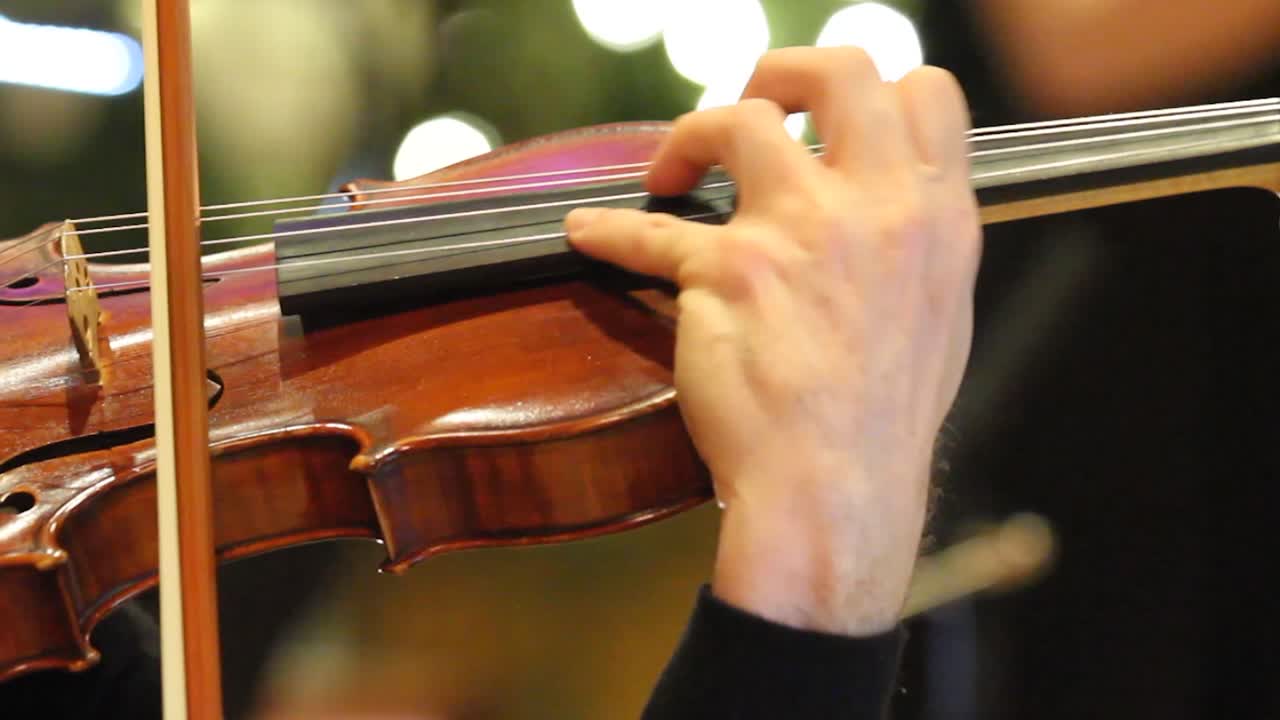 Violin being played with symphony during the holidays