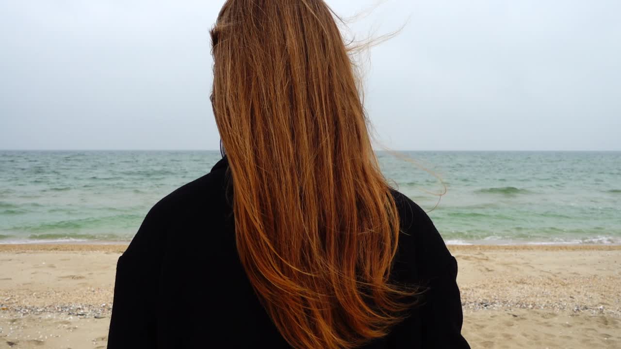 La chica mira el mar. Cámara lenta. Grabación en la playa.