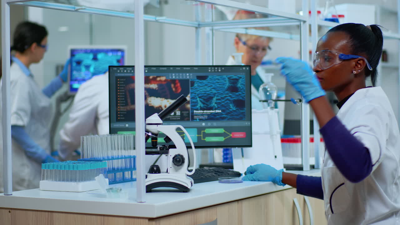 Black woman chemist analysing reaction of virus on microscope