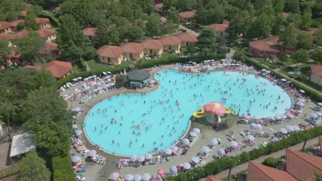 Toma-Aérea-De-La-Piscina-En-Verano-En-El-Camping-Bella-Italia-En-El-Lago-De-Garda,-Italia