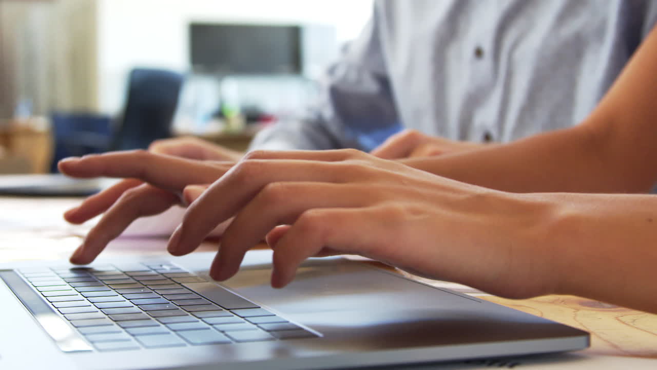 Colleagues work with laptop and documents, close up of hands