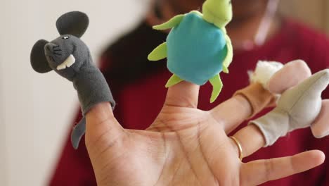 a hand with finger puppets of a mouse, frog, bear, and elephant