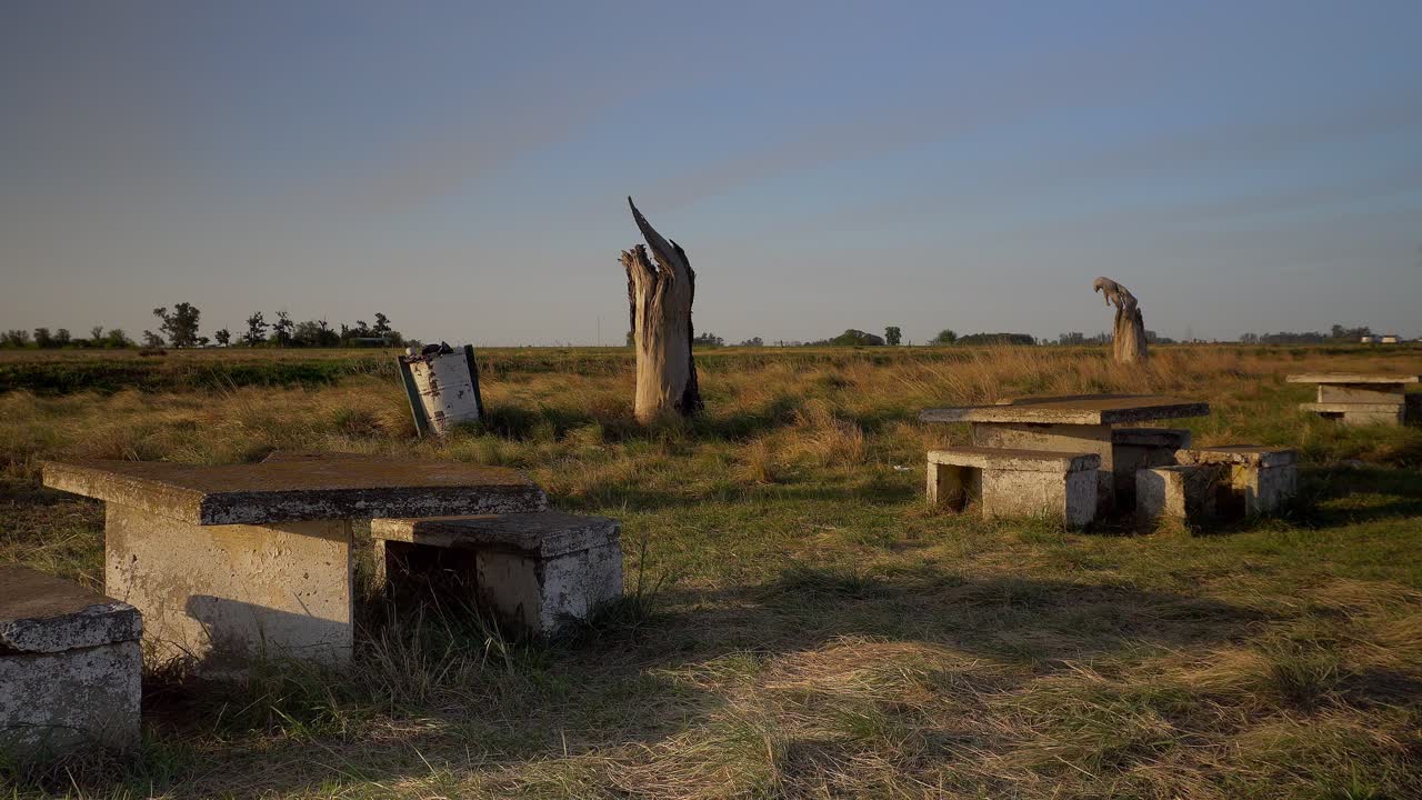 Wide view of a dilapidated rest area at the side of a route at sunset,