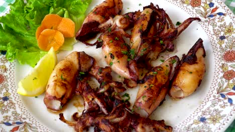mariscos a la parrilla y fritos en un plato mediterráneo tradicional adornado con verduras y frutas de verano - grecia, croacia, italia, montenegro, calamares.