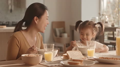 어머니와 딸이 아침 식사를 하고 있습니다.