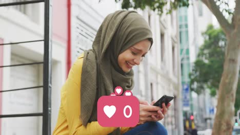 Animation-of-heart-icons-and-rising-number-with-woman-wearing-hijab-using-smartphone-in-street